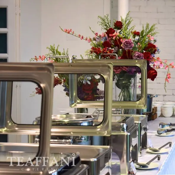 Halal wedding buffet catering setup with stainless chafing dishes and floral arrangements in Kuala Lumpur